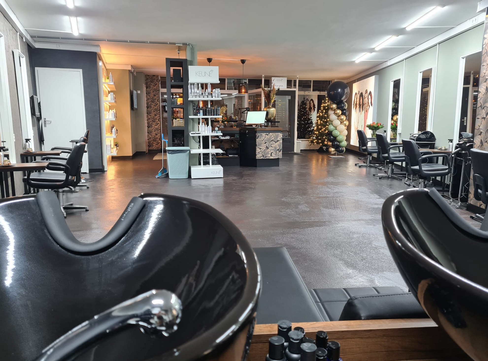 De ruime salon van Haarmode Heemskerk, met wasbakken en kappersstoelen